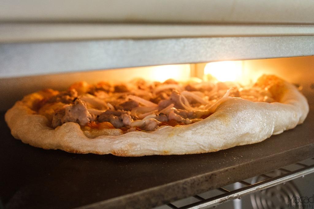 Pizza baking under the broiler on a Steel Craft baking steel